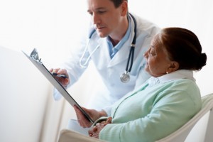 Senior woman reading a file shown by her doctor