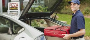 A take-out pizza delivery man delivering take-out food to customer's home.